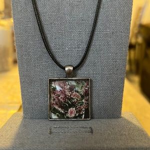 Black necklace with a purple flower pendant